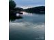 Sunset view of a covered dock reflecting on a serene and calm lake surface at 179 Abington Ln, Troutman, NC 28166