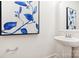 Stylish powder room features a pedestal sink, modern faucet, and a decorative blue floral painting at 217 Halemarg Dr, Belmont, NC 28012