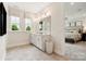 Well-lit bathroom with dual sinks, large mirror, and a view into the adjacent bedroom creating an open feel at 217 Halemarg Dr, Belmont, NC 28012