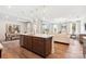 Open kitchen boasts wooden floors, a center island with sink, and seamlessly connects to the living and dining areas at 217 Halemarg Dr, Belmont, NC 28012