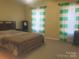 Standard bedroom featuring a queen bed and natural light through striped curtains at 2206 Golden Larch Ln, Waxhaw, NC 28173