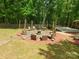 Outdoor stone firepit area with multiple seating options and a deck at 2206 Golden Larch Ln, Waxhaw, NC 28173