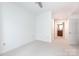 Bright bedroom features neutral carpeting, ceiling fan and view into ensuite bath at 300 W 5Th St # 136, Charlotte, NC 28202
