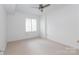 Empty bedroom featuring carpeted floors, a window with shutters, and a ceiling fan at 300 W 5Th St # 136, Charlotte, NC 28202