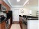 Cozy kitchen featuring stainless steel appliances, wooden cabinets and black countertops at 300 W 5Th St # 136, Charlotte, NC 28202