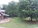 Large backyard with mature trees surrounding a charming log cabin home at 3014 Haigler Rd, Monroe, NC 28110