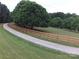 Long driveway lined with a wooden fence leading to a serene country property at 3014 Haigler Rd, Monroe, NC 28110
