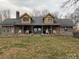 Inviting log cabin home with a covered porch, rocking chairs, and stone accents at 3014 Haigler Rd, Monroe, NC 28110