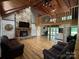 Inviting living room with stone fireplace, wood beams, and hardwood floors offers cozy rustic charm at 3014 Haigler Rd, Monroe, NC 28110