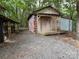 Rustic farm with an outbuilding surrounded by lush trees and greenery and a small hen house at 3014 Haigler Rd, Monroe, NC 28110