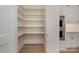 Walk-in pantry with built-in shelving next to wall ovens in an elegant kitchen at 3131 Providence Rd # 1A, Charlotte, NC 28211