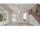 Living room features large windows, hardwood floors, staircase, and a decorative light fixture at 3131 Providence Rd # 1B, Charlotte, NC 28211