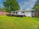 A backyard featuring a well-maintained lawn, a deck with a hot tub, and outdoor seating at 4024 Seaforth Dr, Charlotte, NC 28205