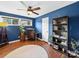 A blue bedroom with hardwood floors, ceiling fan, and ample natural light at 4024 Seaforth Dr, Charlotte, NC 28205