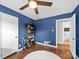 A blue bedroom with hardwood floors, ceiling fan, and natural light at 4024 Seaforth Dr, Charlotte, NC 28205
