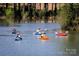 People kayaking on a peaceful pond surrounded by tall trees in a scenic location at 44429 Oriole Dr # 102, Indian Land, SC 29707