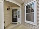 Inviting entryway featuring a classic black door, sidelight window, and elegant exterior lighting at 44429 Oriole Dr # 102, Indian Land, SC 29707