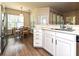 Bright kitchen with white cabinets and stainless steel sink with dining area in background at 44429 Oriole Dr # 102, Indian Land, SC 29707