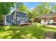Grassy backyard highlighting a custom blue shed with an American flag and lush greenery at 4626 Fairbluff Pl, Charlotte, NC 28209