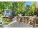 Inviting backyard deck featuring an outdoor dining set and a charming blue shed in a lush, green setting at 4626 Fairbluff Pl, Charlotte, NC 28209