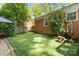 Green backyard featuring an artificial putting green, a hammock, and beautiful landscaping at 4626 Fairbluff Pl, Charlotte, NC 28209