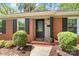 A cozy brick home entrance with black shutters and well-manicured landscaping at 4626 Fairbluff Pl, Charlotte, NC 28209