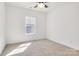Bright, carpeted bedroom with ample sunlight, ceiling fan, and neutral paint at 540 Church St, Locust, NC 28097