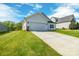 Angle view of house with a well-kept lawn, and attached two-car garage with a concrete driveway at 540 Church St, Locust, NC 28097
