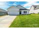 Charming single-story home with a well-manicured lawn and attached two-car garage at 540 Church St, Locust, NC 28097