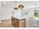 Kitchen island with sink, ample cabinet space, stainless steel appliances, and stylish lighting fixtures at 540 Church St, Locust, NC 28097