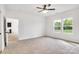 Sunlit bedroom with ceiling fan, neutral carpet, and verdant backyard views from large windows at 544 Church St, Locust, NC 28097