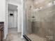 Bathroom showcasing a glass shower with gray tiling and a walk-in closet at 5516 Swaling St, Charlotte, NC 28217