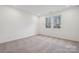 A bedroom that has carpeted floors, a double window, and plain white walls at 562 Mountain View Dr, Monroe, NC 28110
