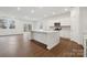 Open-concept kitchen with a large island, white cabinets, stainless steel appliances, and hardwood floors at 562 Mountain View Dr, Monroe, NC 28110