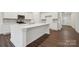 Bright kitchen with white cabinets, quartz countertops, stainless appliances, and a spacious center island at 562 Mountain View Dr, Monroe, NC 28110