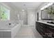 Modern bathroom featuring a soaking tub, marble shower, and double sink vanity at 612 Baldwin Ave, Charlotte, NC 28204