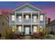 Charming two-story home with a covered porch, columns, front yard landscaping, and fresh paint at 612 Baldwin Ave, Charlotte, NC 28204