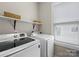 Bright laundry room equipped with modern washer and dryer, plus shelving for storage at 612 Baldwin Ave, Charlotte, NC 28204