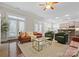 Bright living room with hardwood floors, tan leather sofa, and an open flow to the kitchen and dining area at 612 Baldwin Ave, Charlotte, NC 28204