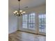 Dining area featuring a chandelier, wood-look flooring, and bright natural light at 668 Sixth Baxter Xing, Fort Mill, SC 29708