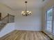 Dining room featuring a chandelier, staircase, wood-look flooring, and bright natural light at 668 Sixth Baxter Xing, Fort Mill, SC 29708