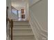 Hallway with carpeted stairs, wood banister, decorative wall trim, and an open view to the kitchen at 668 Sixth Baxter Xing, Fort Mill, SC 29708