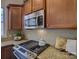 Close up on a kitchen's granite countertop, microwave, range, and wooden cabinets at 668 Sixth Baxter Xing, Fort Mill, SC 29708