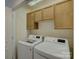 Bright laundry room featuring wooden cabinets and modern washer and dryer at 668 Sixth Baxter Xing, Fort Mill, SC 29708
