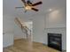 Inviting living room featuring a fireplace with wood mantle, wood floors, and a staircase at 668 Sixth Baxter Xing, Fort Mill, SC 29708