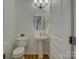 Bright powder room featuring a pedestal sink, modern light fixture, and wood-look floors at 668 Sixth Baxter Xing, Fort Mill, SC 29708