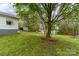 Spacious backyard with green grass, mature trees, and storage sheds for outdoor equipment at 745 6Th Sw Ave, Hickory, NC 28602