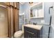 Well-lit bathroom with blue walls, a sink vanity, mirror, toilet and shower with curtain at 745 6Th Sw Ave, Hickory, NC 28602