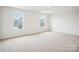 Spacious carpeted bedroom with two windows offering neighborhood views and natural light at 8059 Plymouth Dr, Sherrills Ford, NC 28673