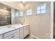 Well-lit bathroom featuring double sinks, white cabinetry, and a tiled walk-in shower at 8432 Norman Forest Rd, Lancaster, SC 29720
